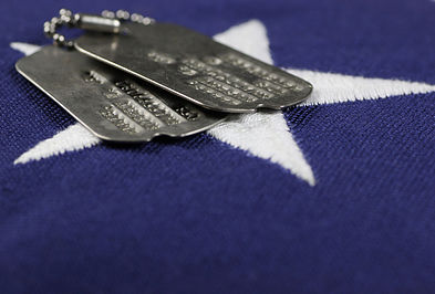 military dog tags rest atop a US flag